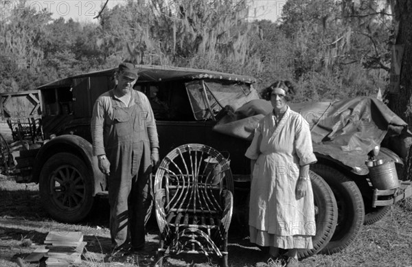 Migrant cane chair maker and wife in front of their automobile home, near Paradis, Louisiana 19380101
