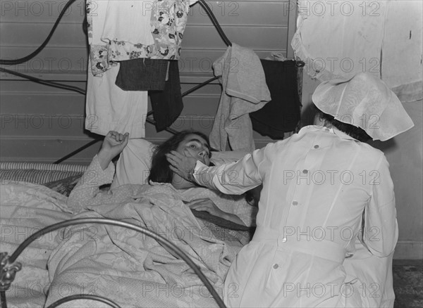 Nurse with patient at a Farm Security Administration (FSA) camp for migratory agricultural workers at Farmersville. 19380101