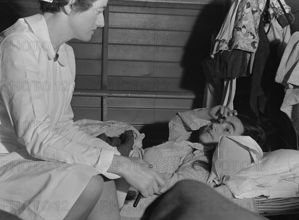 Nurse with patient at a Farm Security Administration (FSA) camp for migratory agricultural workers at Farmersville. 19380101