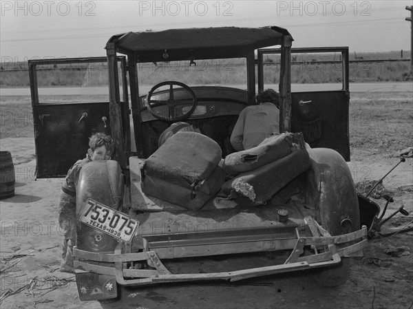 Car of white migrant worker being repaired by owner 19390101