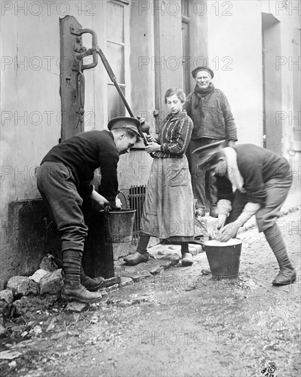 Photograph of British soldiers known as 'Tommys' assisting residents of Étaples, France, during World War I