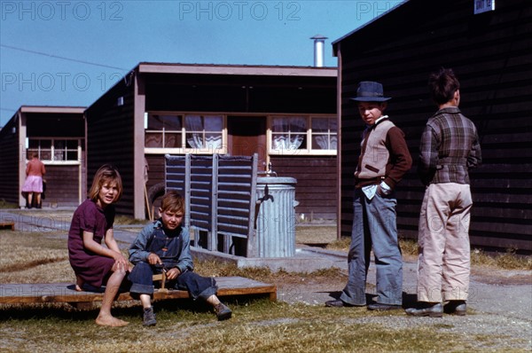 Boy building a model airplane as other children watch. USA. Photographer Arthur Rothstein, 1915-1915.