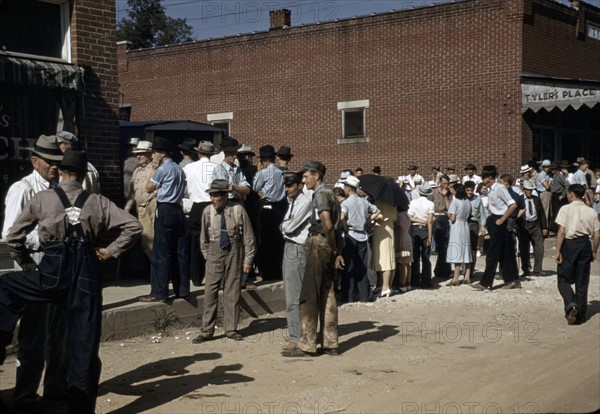 Farmers and townspeople in the centre of town by photographer Marion Post, Wolcott.