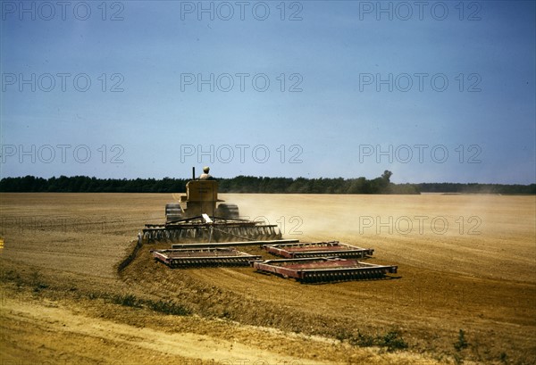 Harrowing a field with a diesel tractor USA 1942