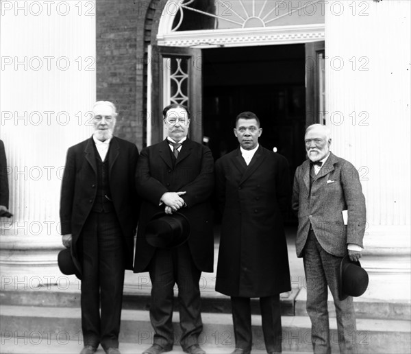 Robert C. Ogden, Senator William Howard Taft, Booker T. Washington and Andrew Carnegie, standing on the steps of a building, at the Tuskegee Institute