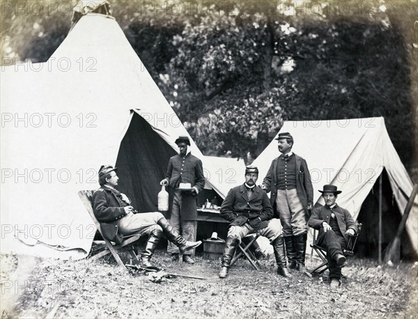 Union officers rest while their african-American orderly serves drinks. Warrenton, Virginia, during the American Civil War 1862