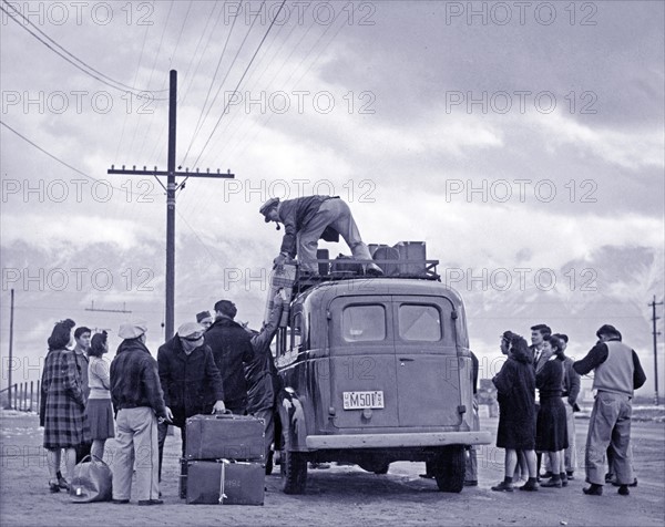 Photographic print of a loading bus leaving Manzanar for relocation