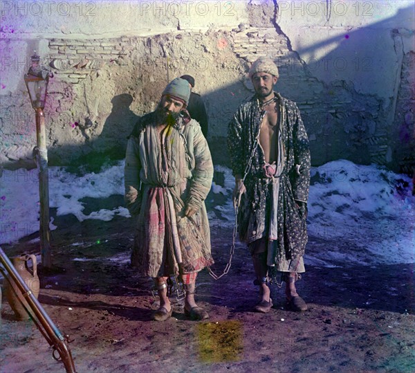 Two prisoners in shackles.