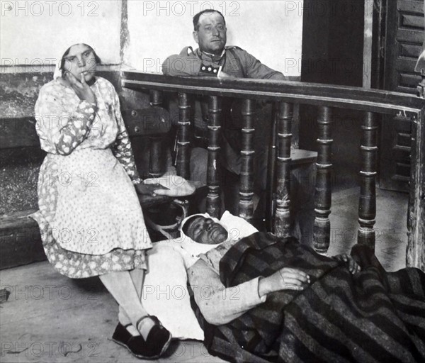 A wounded peasant farmer lies injured and under guard during peasant riots in Spain 1930