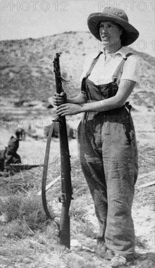 woman civilian stands guard with a rifle during the Spanish Civil War