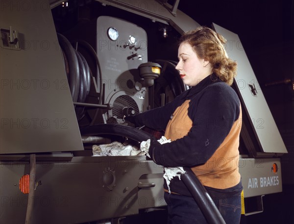 Agnes Cliemka checking the gasoline hoses on the gasoline trailers