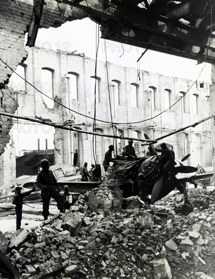 Troops inspecting pieces from grounded fighter plane