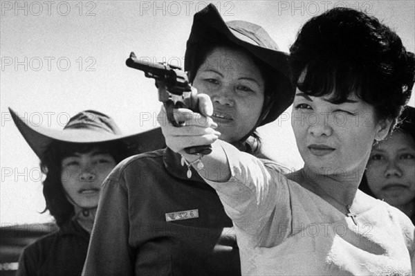 Photograph of Madame Nhu shooting a gun