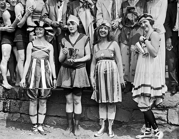 Photograph of young women wearing appropriate swimwear and holding trophies