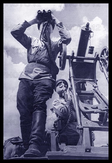 Soviet Russian Anti Aircraft gunners scan the skies while wearing gas masks during World War Two. 1941