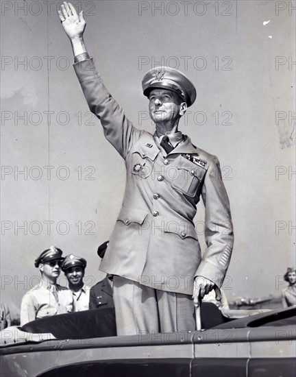 General Wainwright, standing in car, waving to crowd gathered at La Guardia