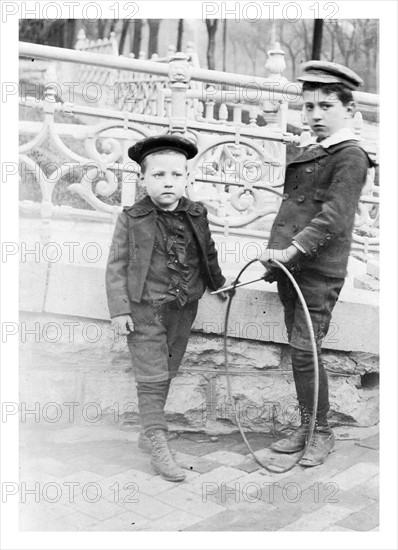 Two boys playing with circular hoops c1900