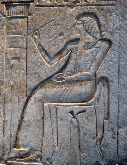 Wall relief fragment with a man decorating his tomb, Limestone. Egyptian.