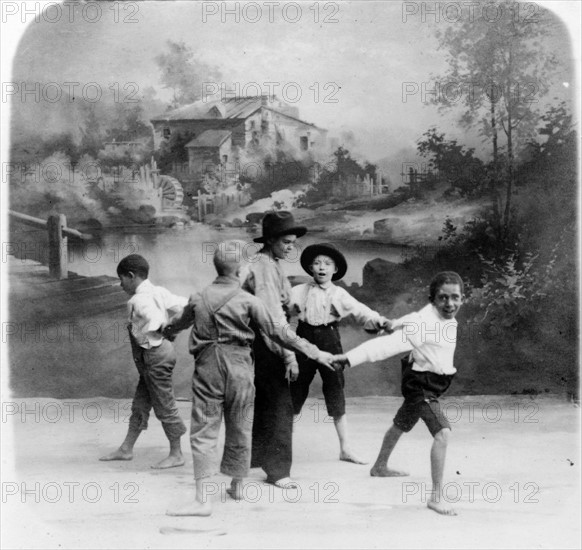 African American and white boys in circle around another boy