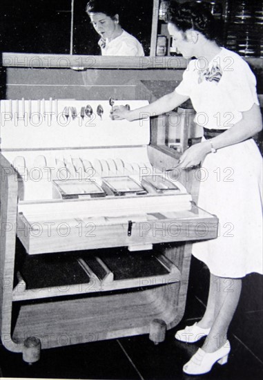 Housewife replacing silverware into a specialised storage system