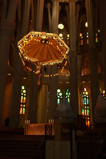 View of the suspended crucifix and glass altar within the Basílica i Temple Expiatori de la Sagrada Família