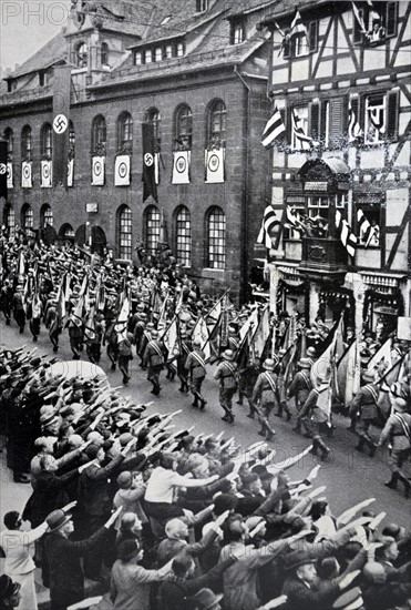 Armed forces Day in Nuremberg, 1935; Soldiers parade while onlookers give Nazi salute.