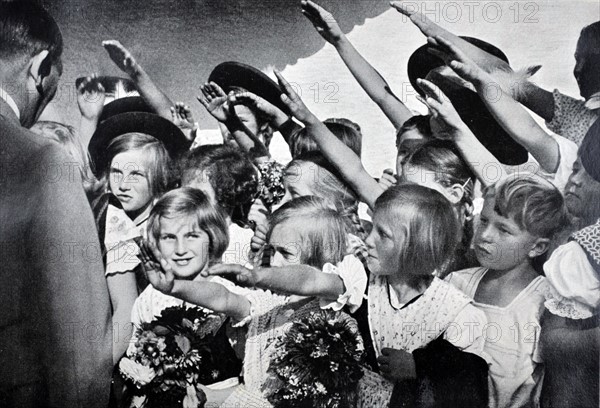 Adolf Hitler, saluted as he greets young children