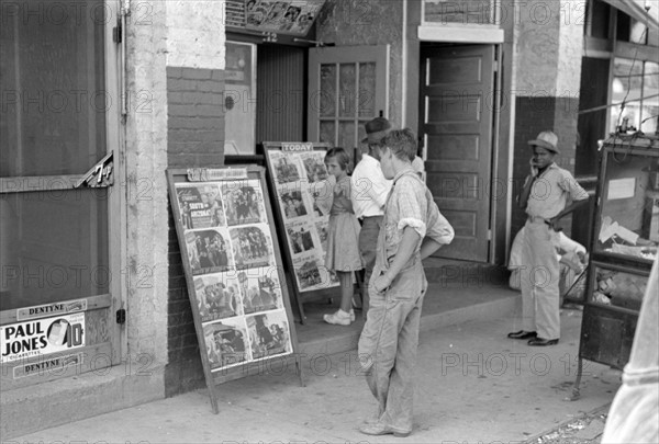 Children looking at posters in front of movie, Saturday, Steele, Missouri 1938