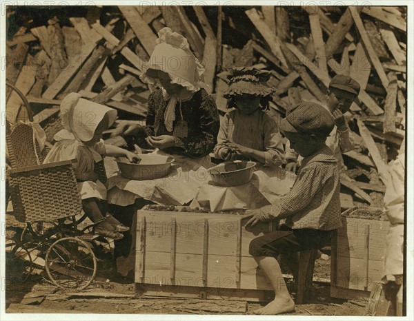 Mother and children hulling strawberries