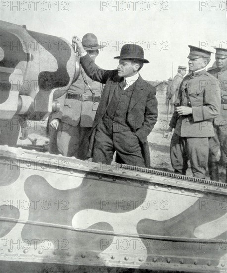 US Secretary of war visits a camouflaged artillery gun in France in WWI.