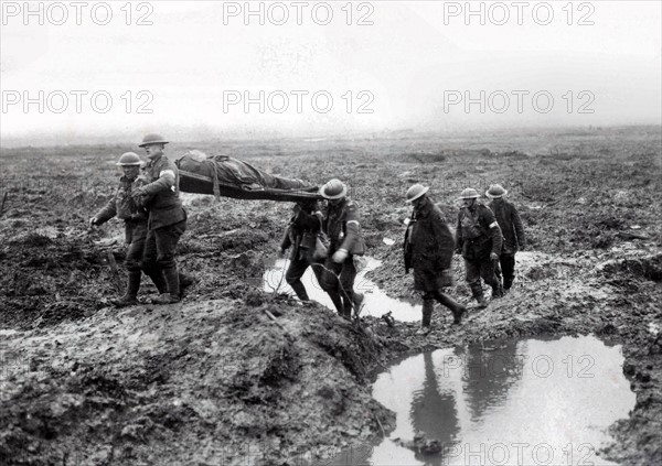 Canadian soldier is taken by fellow troops towards a medical post.