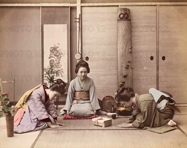 Colour Photograph of two Japanese women greeting another woman with a gift box tied with mizuhiki