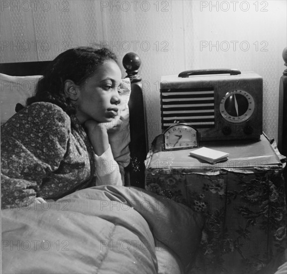 Photograph of an African-American woman listening to the radio