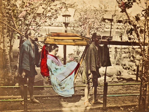 Colour photograph of a Japanese women in basket palanquin