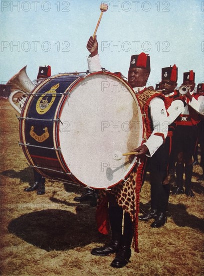 Colour photograph of Salifu Konkomba playing the big drum in the famous band of the Gold Coast Police