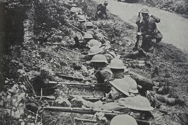 Photograph of Soldiers taking up position by the roadside