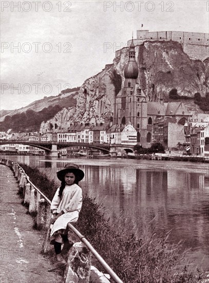 Girl sitting on a barrier by the Citadel of Dinant, Belgium.