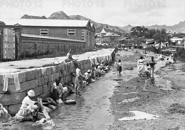 washing laundry in the stream running through a side street, California. 1904