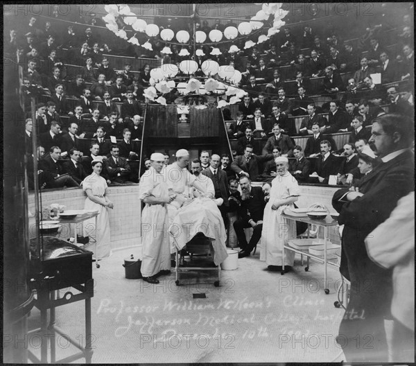 Photograph of surgeons standing around a patient