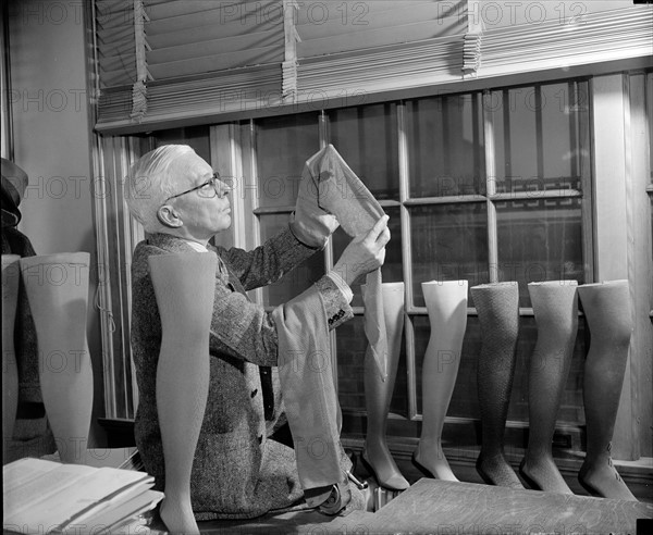 fabric technician, is shown examining one of the cotton stockings which they are trying to popularize in Japan