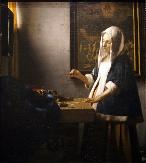 Painting titled 'Woman Holding a Balance' by Johannes Vermeer