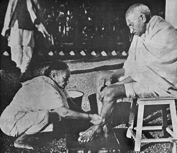 Mahatma Gandhi having his feet washed, by his wife Kasturba, at Sevagram a village in the state of Maharashtra, India