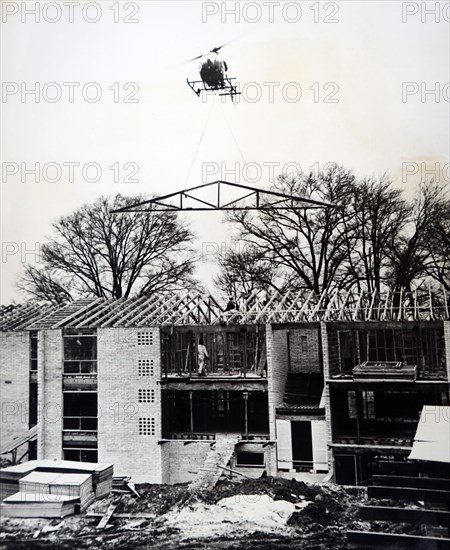 Photograph of a helicopter being used to aid the construction of a building