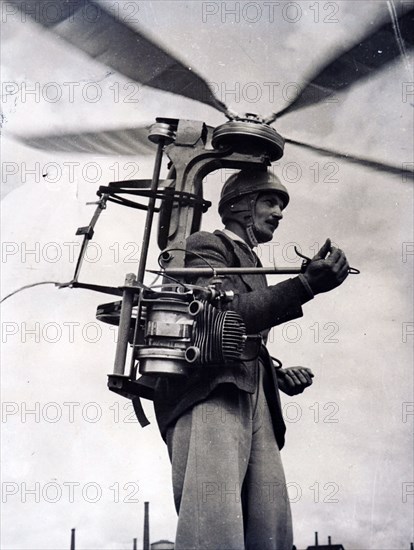 Photograph of Georges Sablier demonstrating his latest invention, a portable helicopter for which he won a special award at the international helicopter competition and show at Saint Etienne, Central France