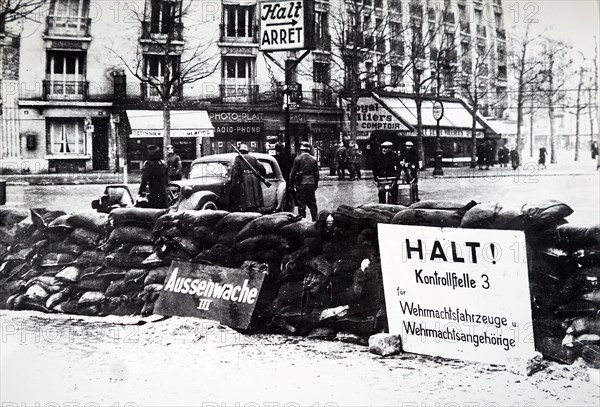 Photograph of German soldiers searching a vehicle at a road block in Paris, after the Invasion of France in 1940, in World War Two
