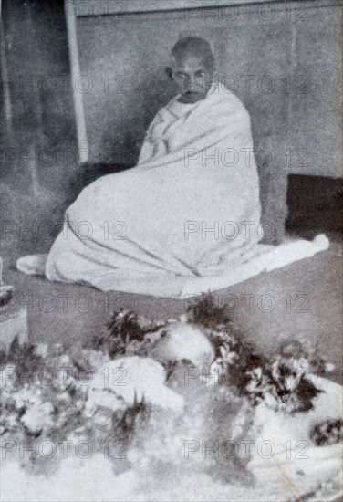 Gandhi sits in mourning by the body of his wife Kasturba 1944