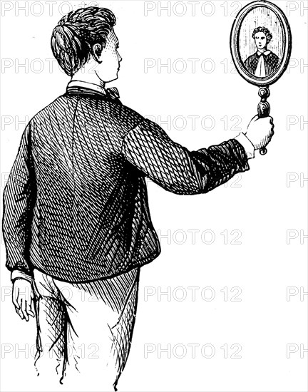 A young boy looking at himself in a mirror