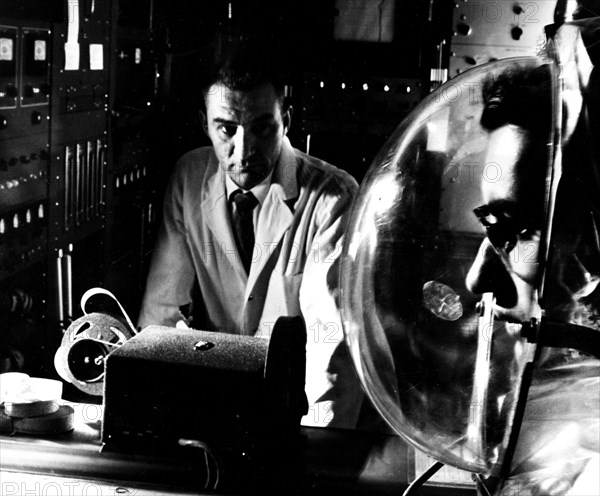 Photograph of a physicist monitoring a complex experiment using a closed respirometer