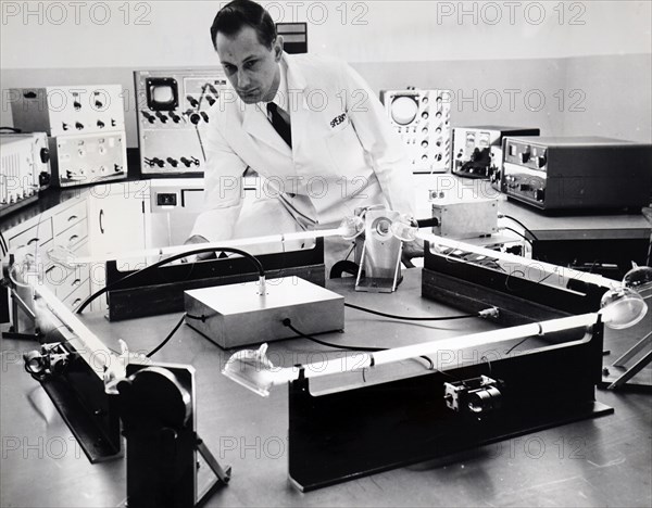 Photograph of a scientist testing a 'closed-circuit' laser that appears to be superior to a gyroscope for guiding spacecraft, rockets, airplanes and ships