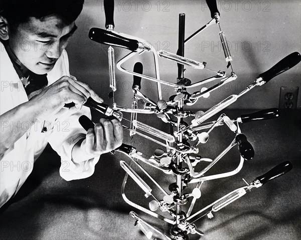 Photograph of a technician holding a laser 'demodulator' used to convert laser light beams into television signals and radio sounds